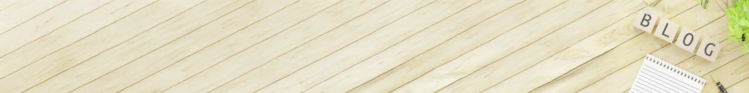 板張りのテーブルの端にブログロゴとノートとペン