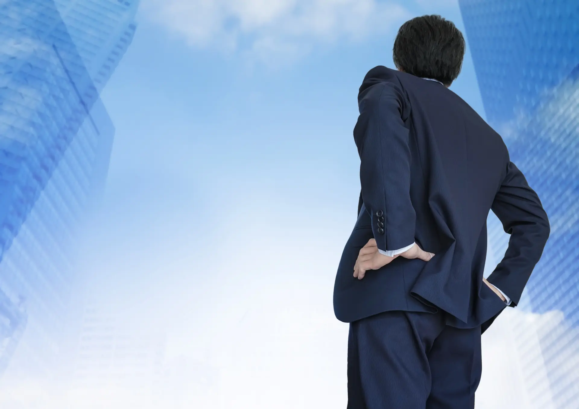 空を見上げるスーツ姿の男性