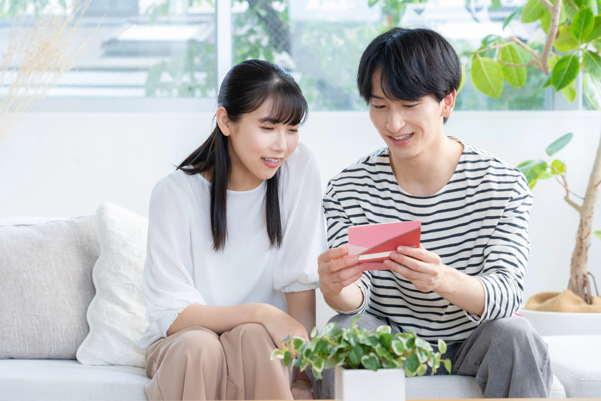 ビングで通帳を見てほほ笑む夫婦