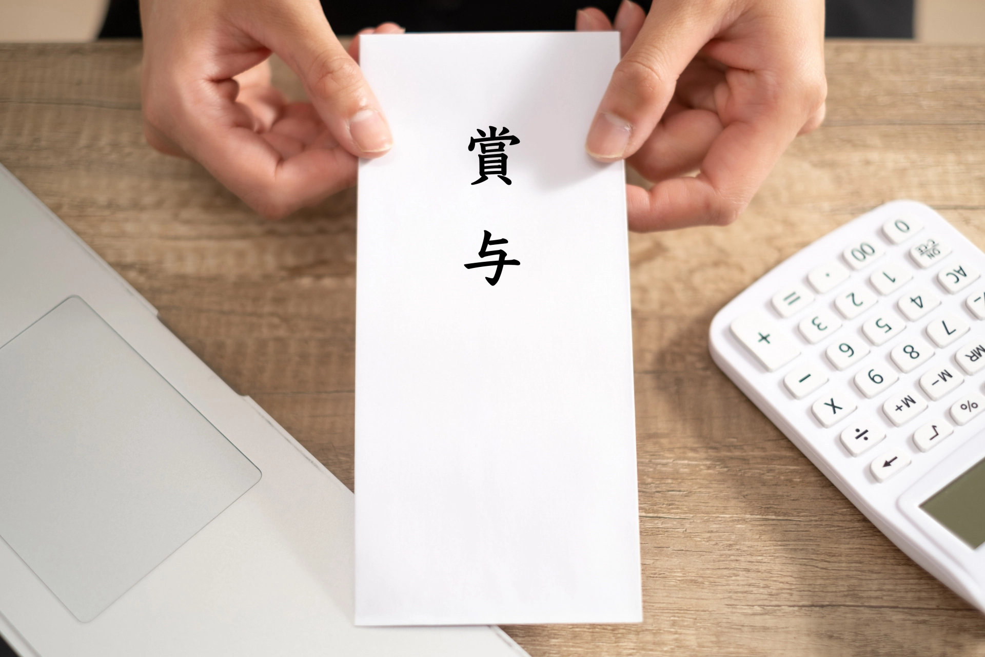 賞与の封筒を手渡す手