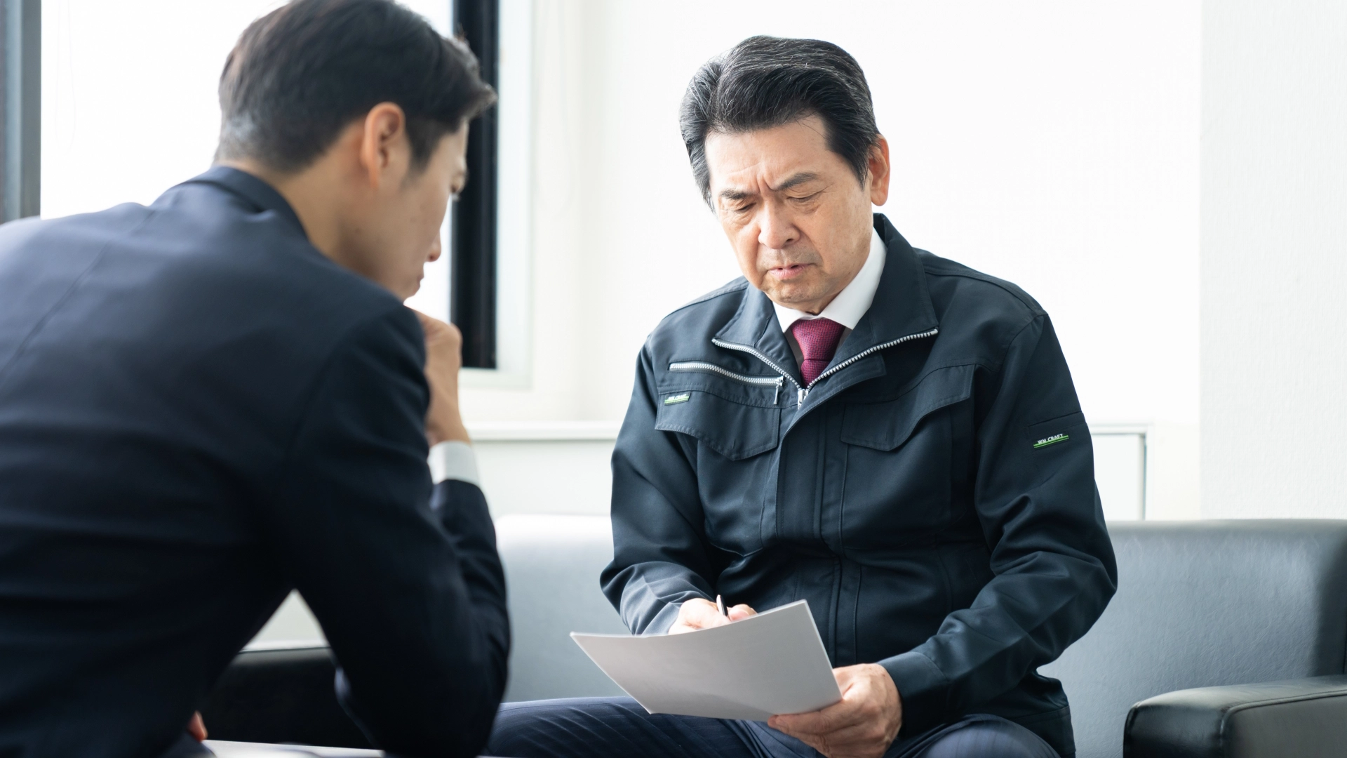 金融機関と交渉する渋い表情の経営者