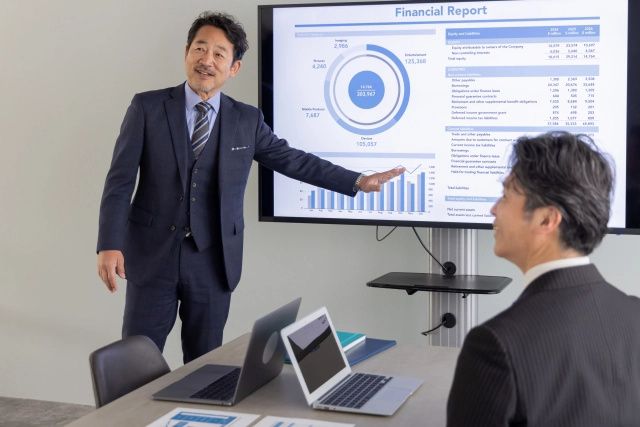 画面を説明するビジネスマン