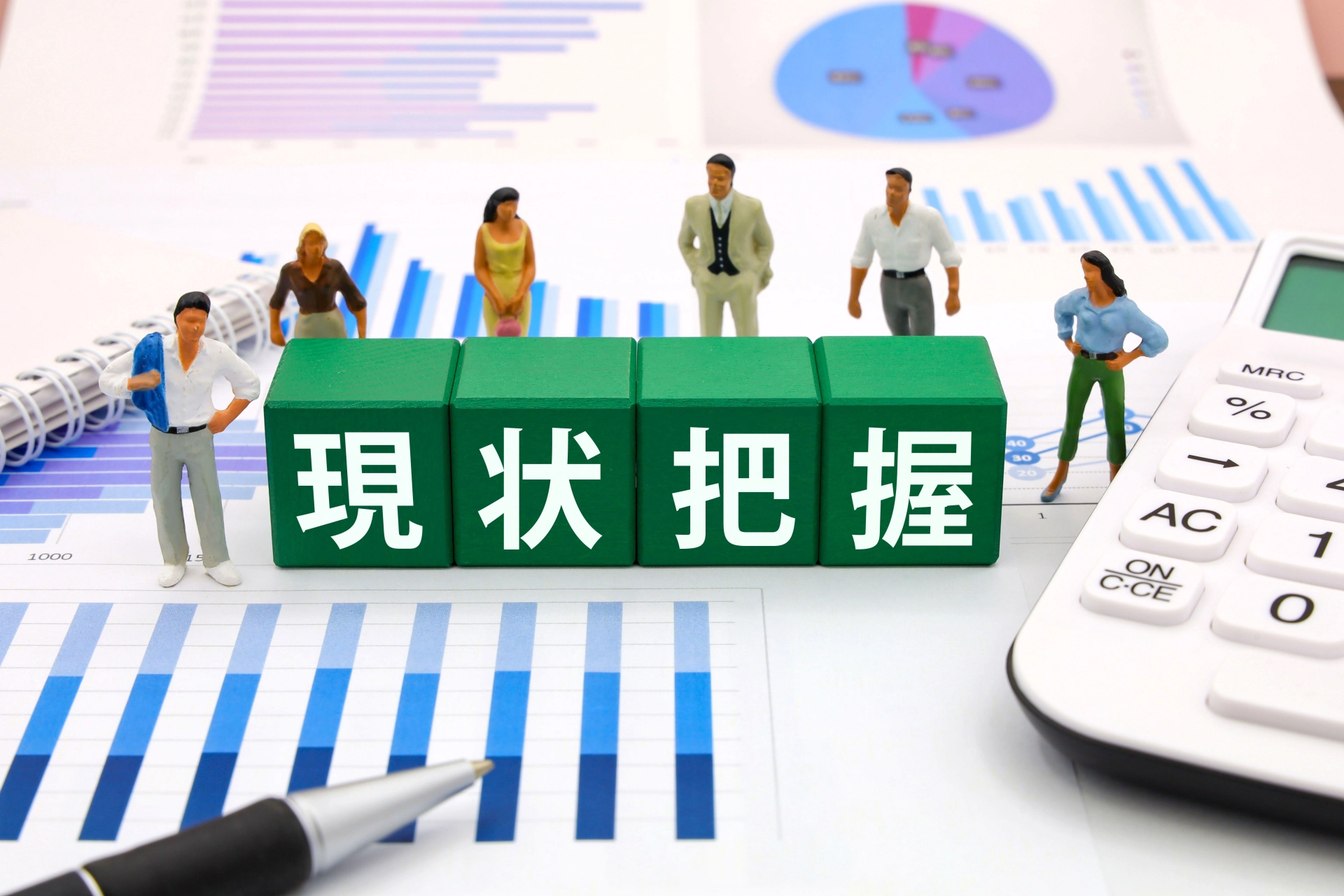 グラフ資料の上の人形と「現状把握」の文字ブロック